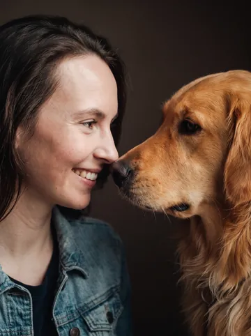 Nose to nose sample: a woman with long brown hair and her golden retriever